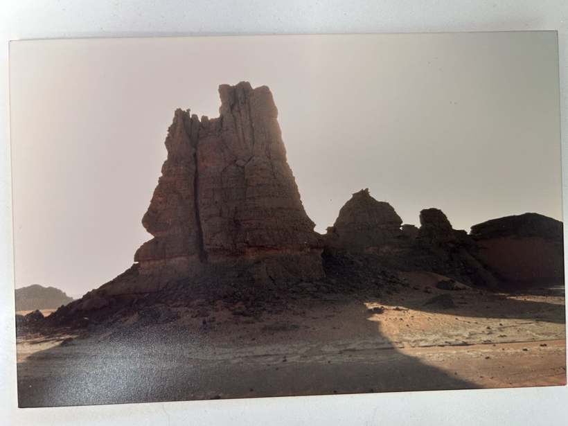 Une aiguille de roche brune dressée dans un paysage aride.